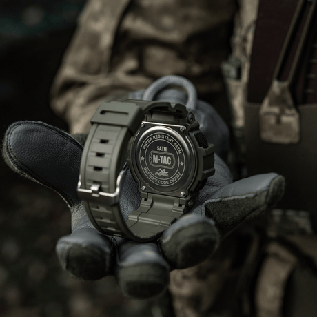 M-Tac Tactical Klocka med Kompass 2233 i militär stil, visas på en hand med handskar, lämplig för friluft och taktisk användning, vattentät 5ATM.