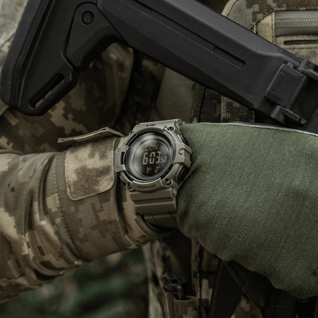 M-Tac Tactical Klocka med Kompass 2233 i ett taktiskt friluftsscenario, visar robusthet och funktioner som kompass och LED-bakgrundsbelysning.