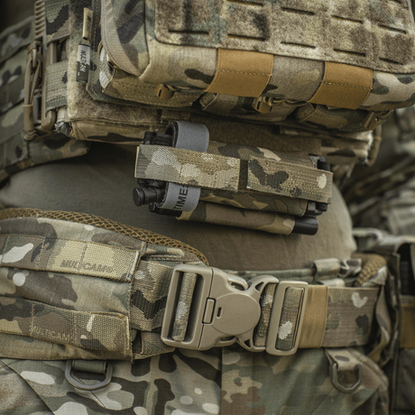 M‑Tac Tourniquet Pouch Elastic Gen.5 på taktisk udstyr, lavet af Cordura 500D, med elastiske bånd og hurtig adgang fra begge sider.
