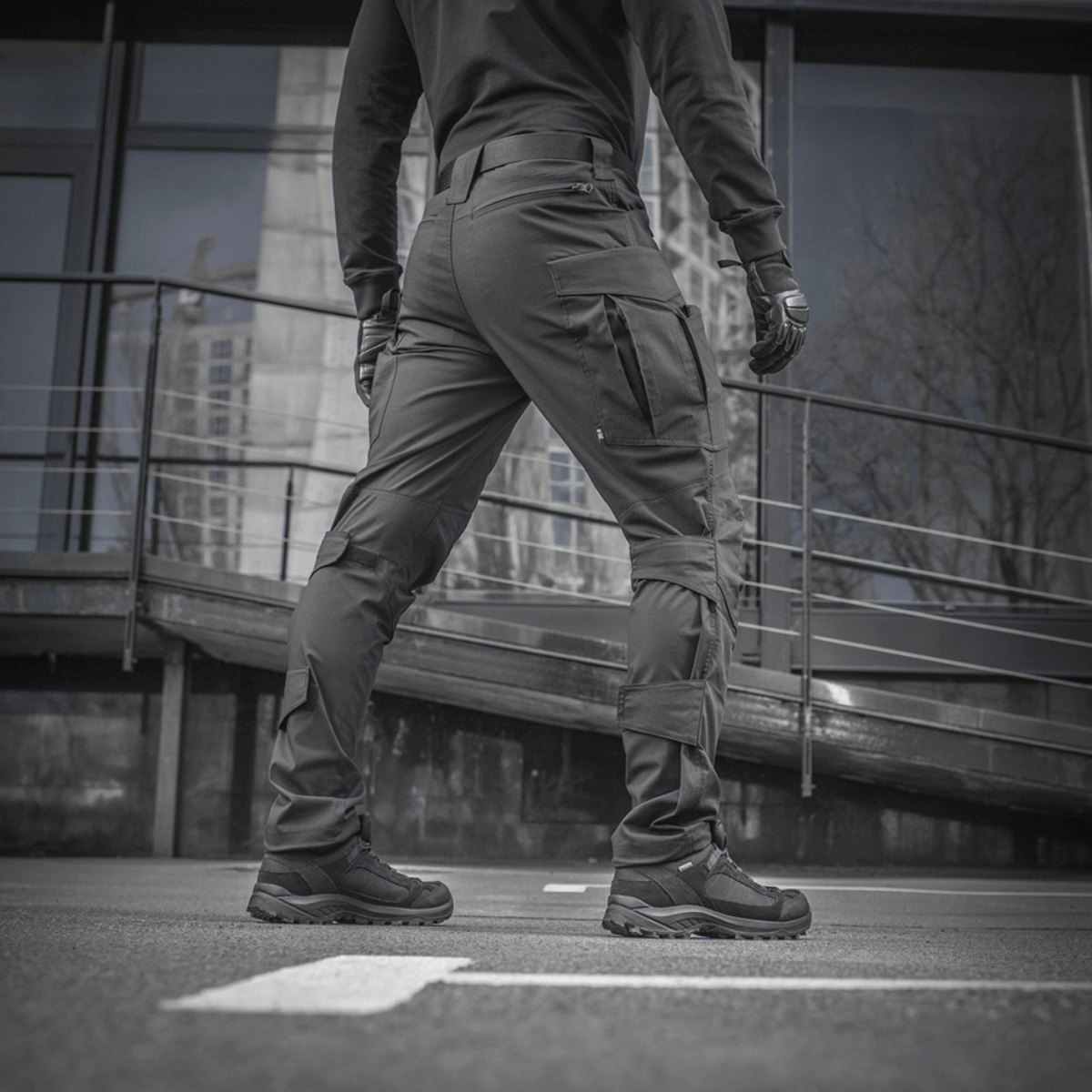 Mand iført M-tac Taktiske Bukser Conquistador Gen. I Flex til udendørsaktiviteter og arbejde, lavet af slidstærkt polycotton Rip-stop Flex.