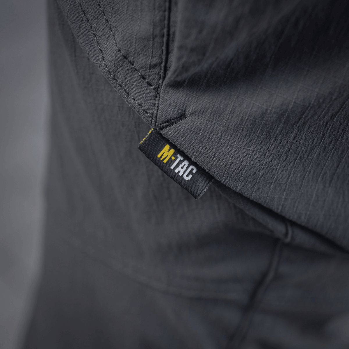 Etiketten på M-Tac Bukser Sahara Flex Light, der viser stoffets fleksibilitet og holdbarhed, ideelt til sommerbrug.