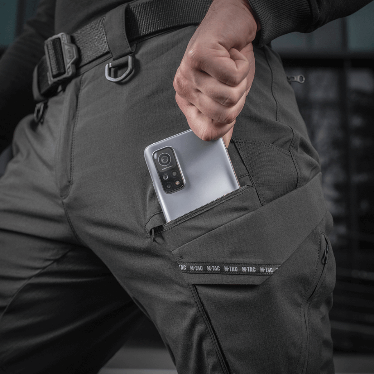 Person iført M-Tac Bukser Aggressor Summer Flex viser lommefunktion, ideel til sommerkomfort og holdbarhed.