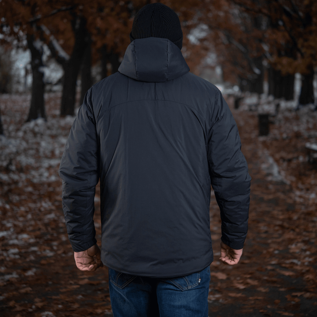 Mand iført M-Tac Paladin Jakke i en efterårsskov, perfekt til temperaturer fra 0 til -15°C, stilfuldt design fra Toray