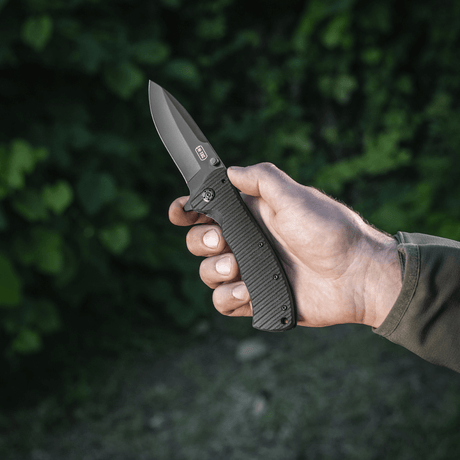 M-Tac Outdoor & Militär fällkniv - Type 7 med kromat rostfritt stålblad hålls i hand, tillverkad för taktiska ändamål.