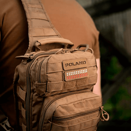 Man med brun väska med M‑Tac Patch Poland End-to-End 25x80 i Cordura 500D, fäst med velcro. Visning av lasergravyr.