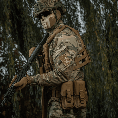 Taktisk soldat bär M-Tac Patch Face of War (Broderi) på ärmen, inspirerad av Vietnamkrigets dödskort, i kamouflagekläder.