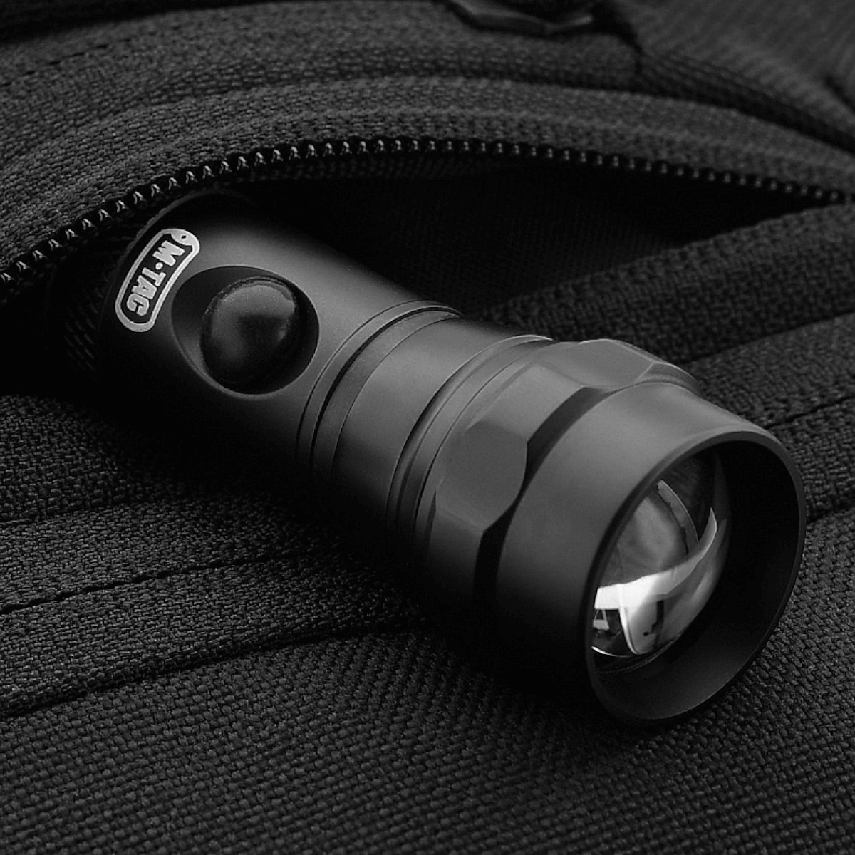 Lommelygte i en M-Tac Carry Sling Taske Elite Gen.IV med Velcro lomme, designet til skjult og sikker bæring af udstyr.