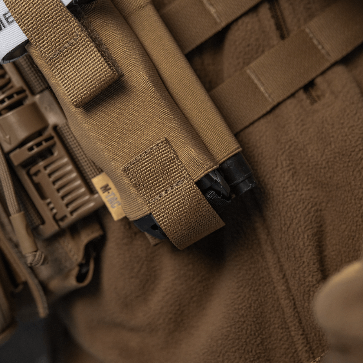 M-Tac Elastisk Tourniquet Pouch Molle Gen.III monteret på taktisk udstyr, lavet i Cordura Squadron for sikker opbevaring.