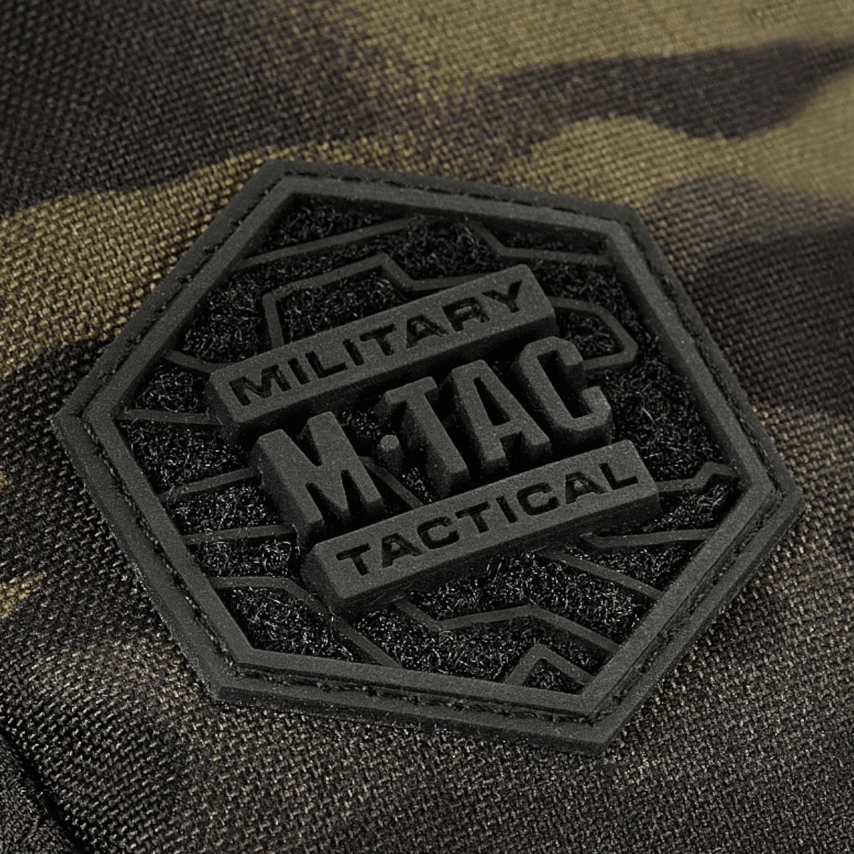 Nærbillede af M-Tac Sling Pistoltaske Elite Hex mærke på robust Cordura materiale med camouflage design.