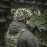 Soldat iført M‑Tac Vilha Hjelmdæksel Elite i Multicam skovkamouflage, designet til FAST hjelme, set fra siden.