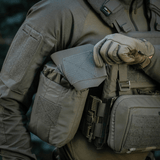 Soldat bruger M‑Tac Medic Pouch Vertical Large Elite til nem adgang til førstehjælpsudstyr, lavet af holdbart Cordura 500D materiale.
