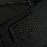 Nærbillede af et sort stofmateriale med en velcro strop.