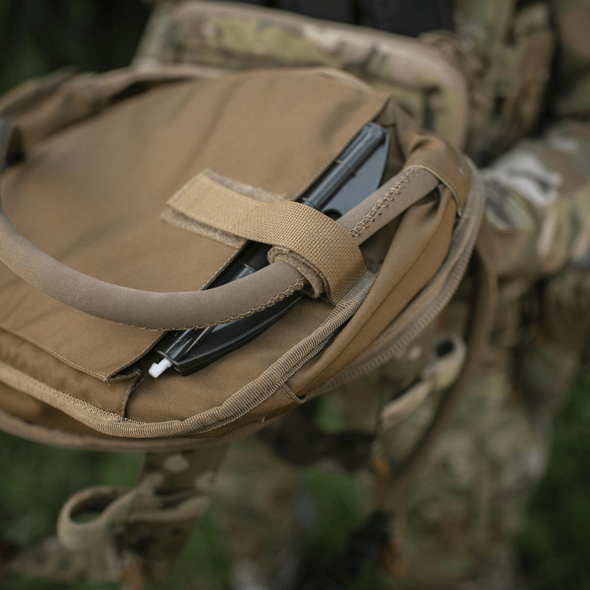 Brun rygsæk med camouflage-mønster og bærbar computer opbevaret indeni