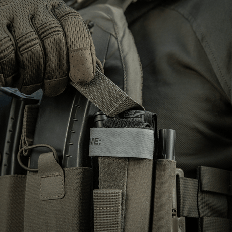 M‑Tac Tourniquet Pouch Elastic Gen.5 fastgjort til taktisk udstyr med elastisk bånd og velcro, viser hurtig adgang og sikker opbevaring.
