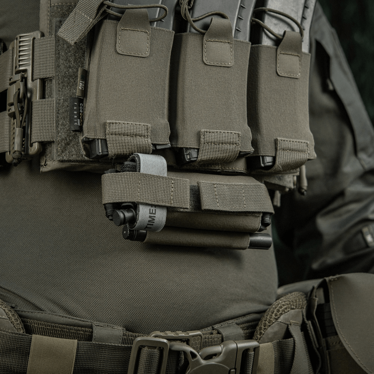 M-Tac Tourniquet Pouch Elastic Gen.5 monteret på taktisk udstyr, lavet af Cordura 500D, med elastisk bånd til hurtig adgang.