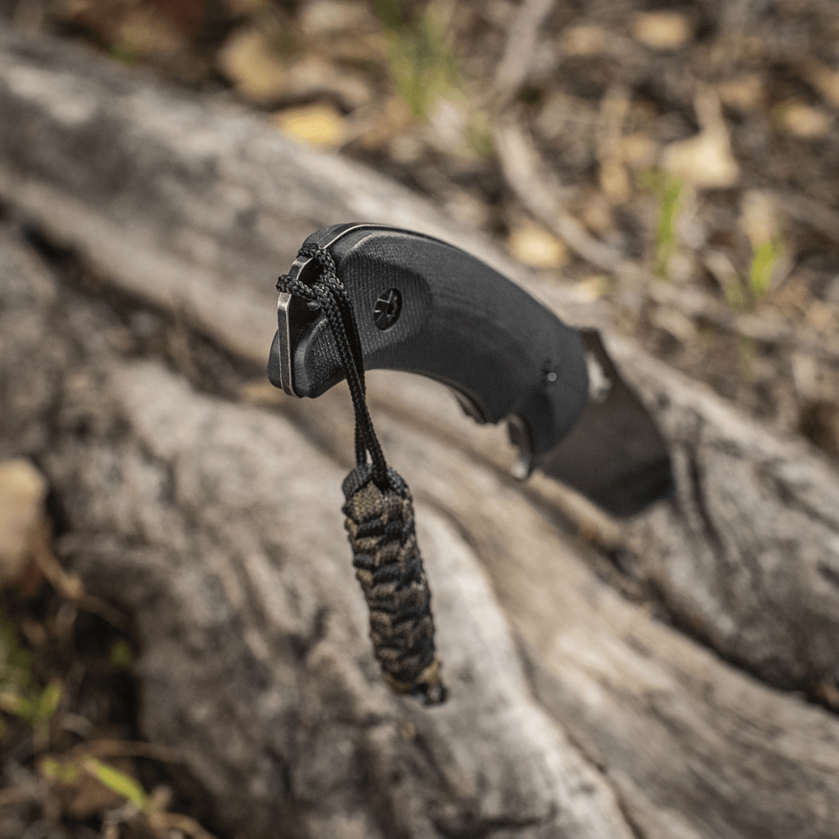 M-Tac Knife Lanyard Helix Skull på lommekniv med flettet paracord, giver stil og karakter til kniven, fotografert i naturligt miljø