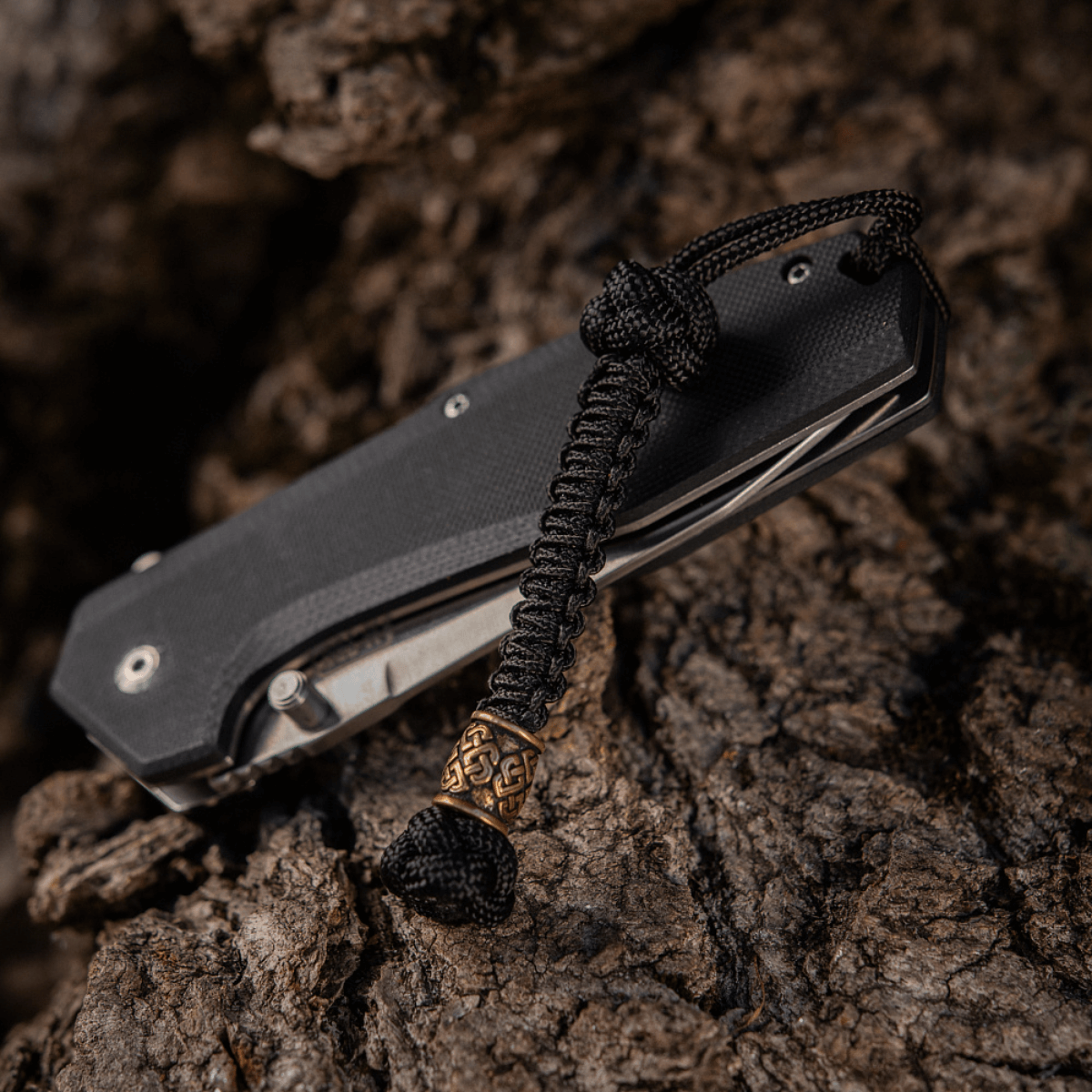 M-Tac Knife Lanyard Celtic flettet paracord lanyard med celtic design på sort kniv, stilfuldt tilbehør til knive og udstyr.