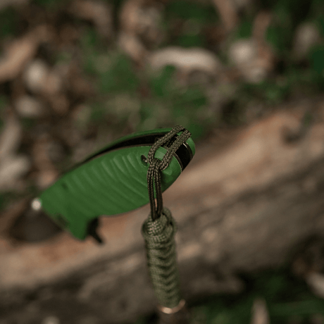 M-Tac Viper Lanyard Scandinavian med grønt paracord og Viper-perle vedhæftet til en kniv i udendørs miljø.