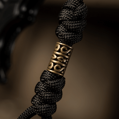 M-Tac Zeus Lanyard i flettet paracord med dekorativt Zeus-design, ideel til kniv, lygte eller udstyr. Stilfuld, fleksibel og holdbar.