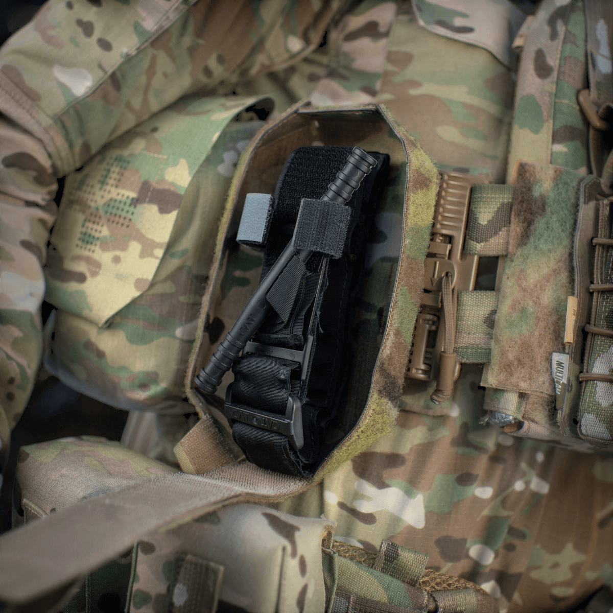 M-Tac Lomme til Tourniquet Closed monteret på camouflage-taktisk vest, klar til nødsituationer og effektiv førstehjælp.