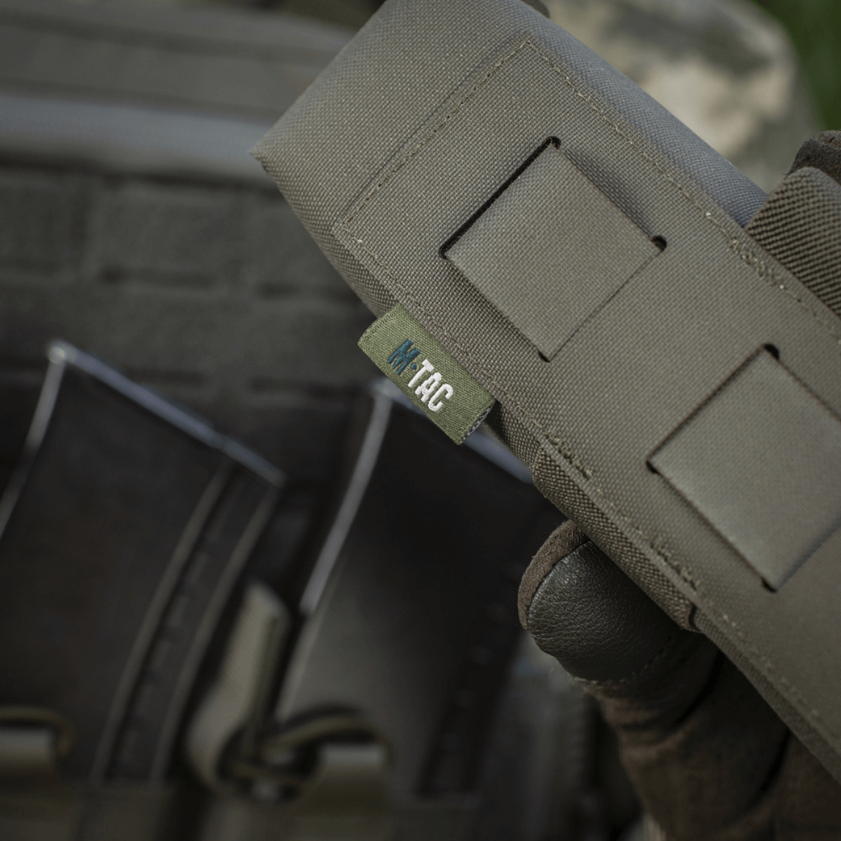 M-Tac Lomme til Tourniquet Closed i brug, tæt på synlig M-Tac logo, designet til pålidelig beskyttelse af tourniquet i felten.