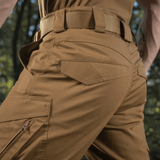 Nærbillede af M-Tac Shorts Aggressor Gen.II Flex i rip-stop materiale, der viser holdbarhed og taktisk design i skovmiljø.