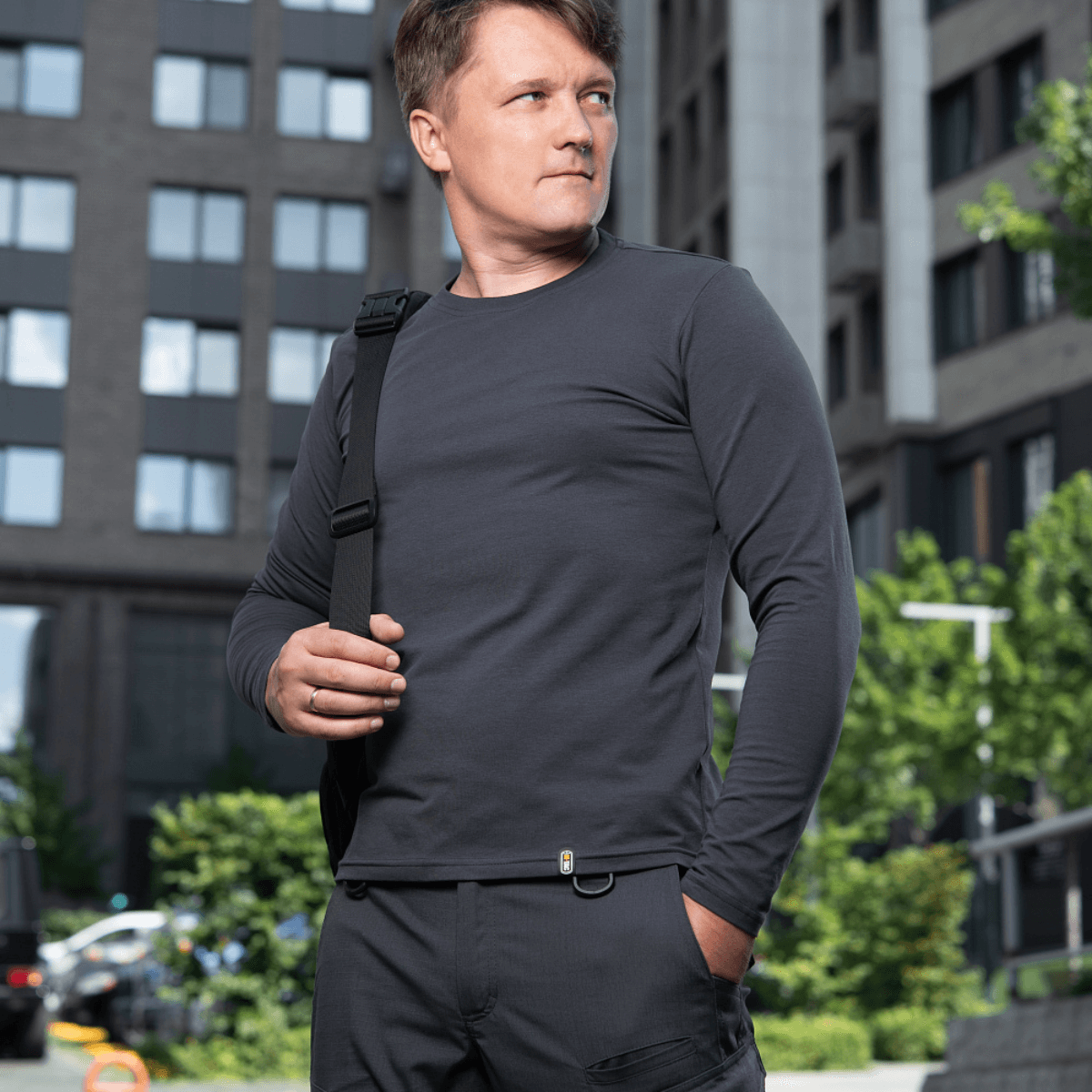 Mand iført M-Tac Long-sleeve T-shirt 93/7 i urbane omgivelser, perfekt til hverdag og friluftsliv. Kvalitetsstoffet fremhæver muskelkonturer.