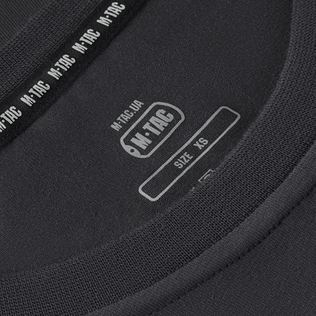 Close-up of M-Tac T-shirt 93/7 Summer label showing size XS, emphasizing high-quality materials for comfort and fit in everyday use.