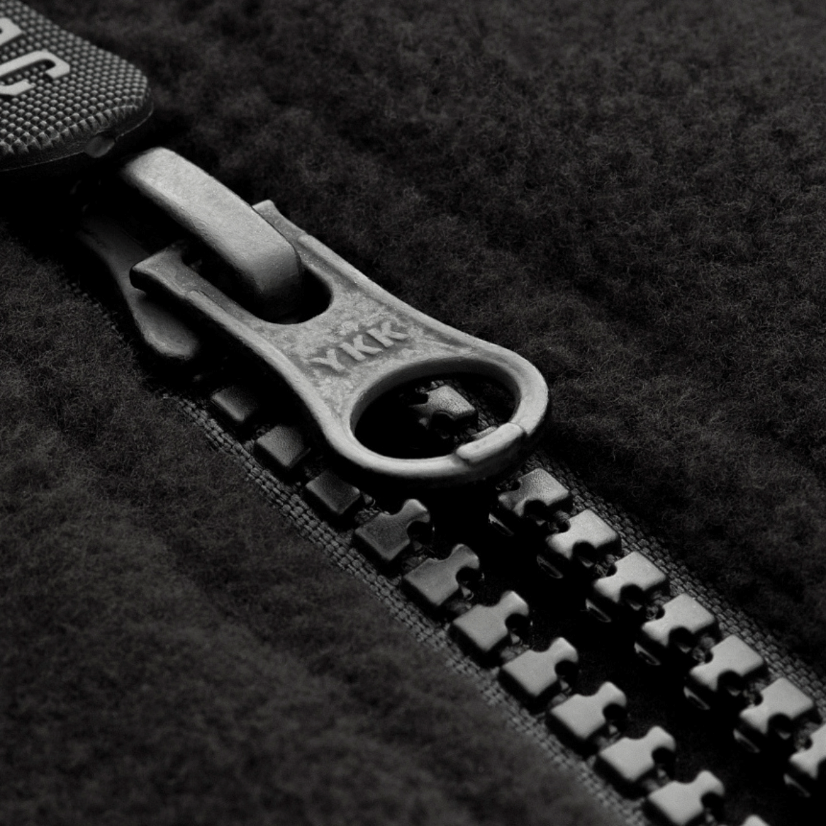 Nærbillede af lynlås på M-Tac Alpha Microfleece Jakke Gen.II, der viser holdbarhed og kvalitet i outdoor-beklædning.