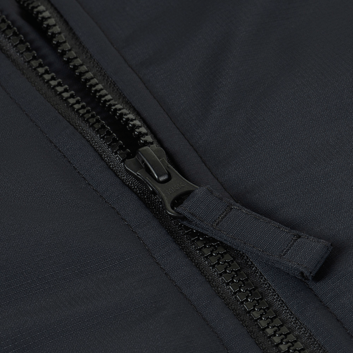 Nærbillede af lynlås på M-Tac Alpha Gen.III Pro Vinterjakke, viser sort nylonmateriale og robust lynlåsdesign.
