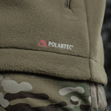 Nærbillede af M-Tac Combat Fleece Polartec Jakke i olivengrøn med Polartec-logo, ideel til taktisk og casual brug. Perfekt til alle sæsoner.