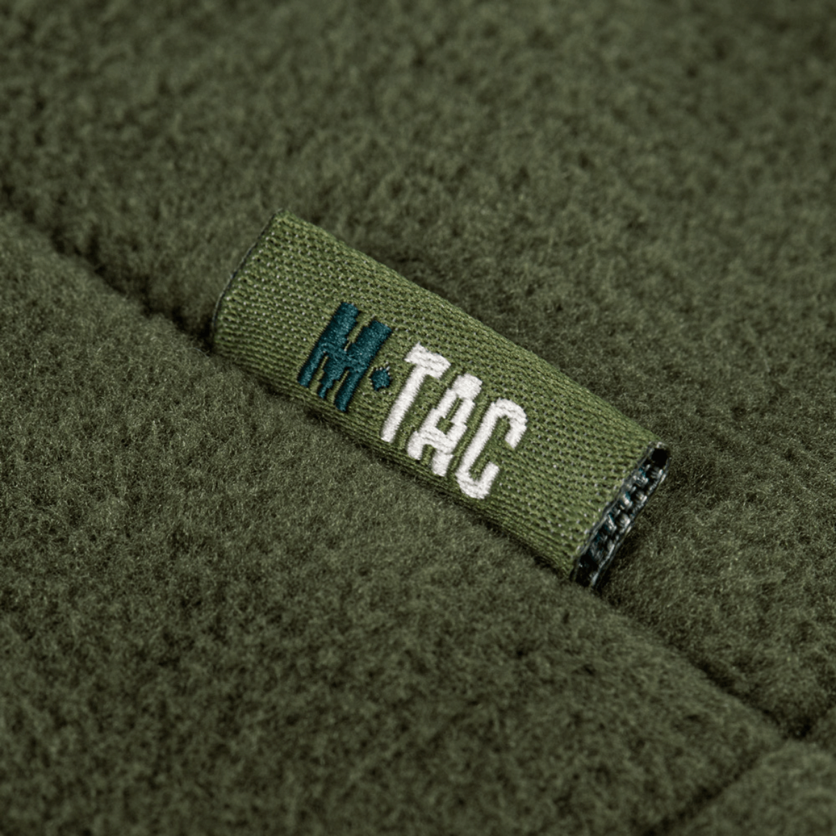 M-Tac Combat Fleece Polartec Jakke logo på grøn fleece stof.