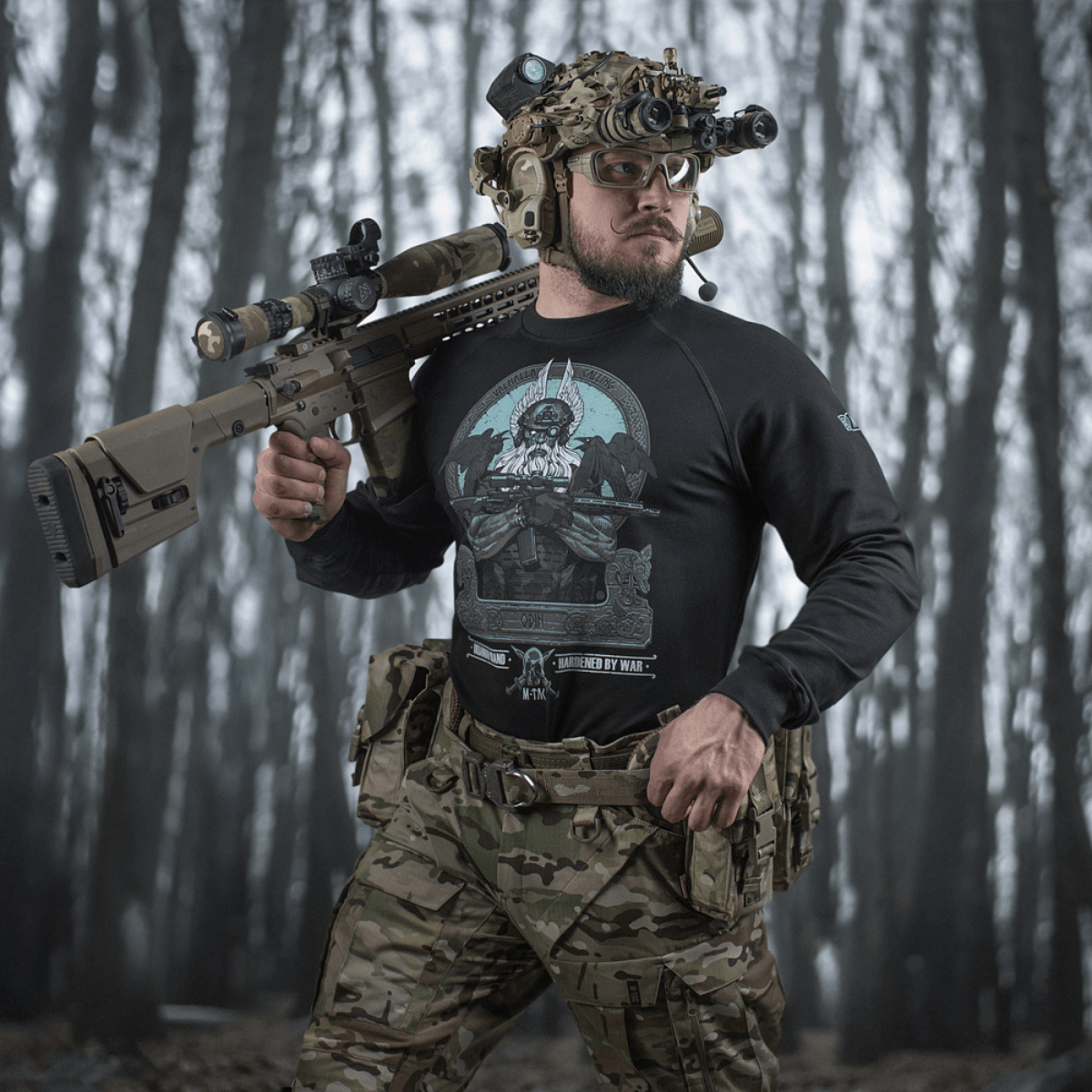 M-Tac Raglan Odin Mystery båret af mand i taktisk gear i skovmiljø.