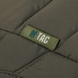 Detalje af M-Tac Damevest Primaloft med slidstærkt vandafvisende yderstof. Fokus på M-Tac logoet og den tekniske kvalitet.