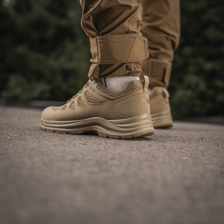 Person iført brune M-Tac Tactical Sneakers IVA til trekking og outdoor-aktiviteter i naturen.