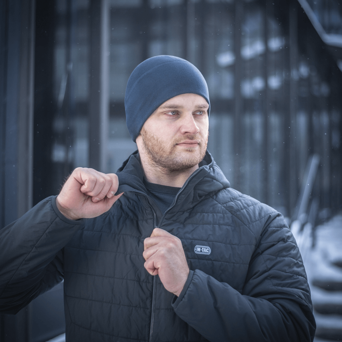 Mand iført M-Tac Fleece Watch Cap Light Polartec og jakke i vintervejr.
