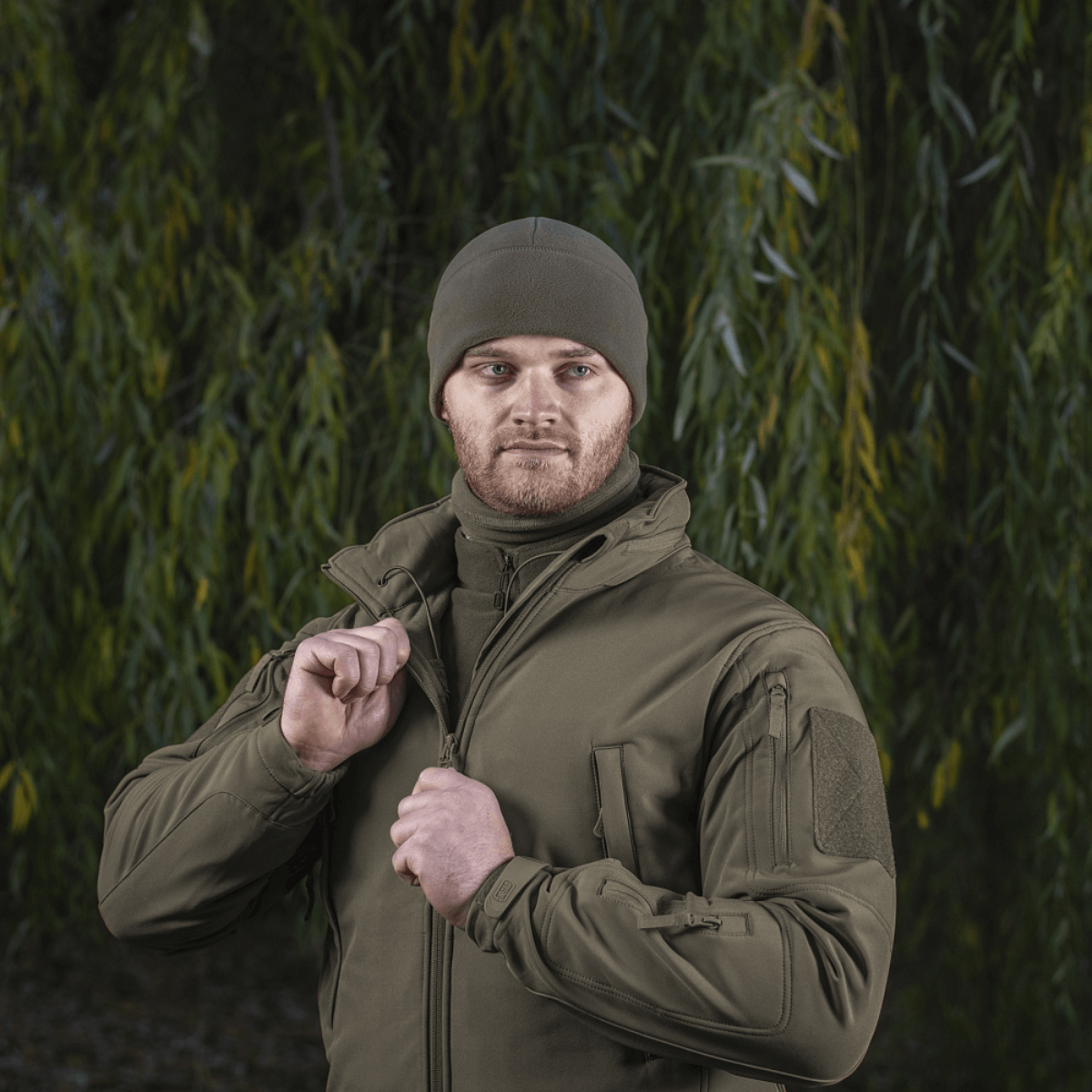 M-Tac Fleece Polartec Watch Cap i brug, passer perfekt til udendørsaktiviteter om vinteren og beskytter mod kulde og vind, set i grøn skov.
