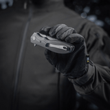 Person holding M-Tac Outdoor & Militær foldekniv - Type 6 with black G10 composite handle in gloved hand