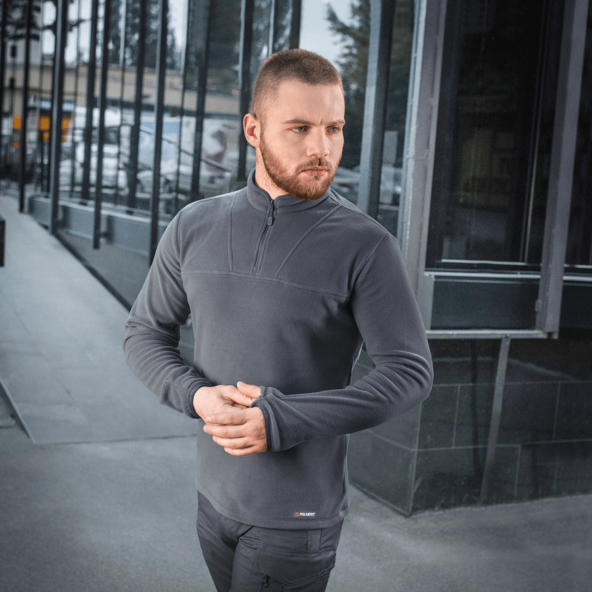 Mand iført en stilren M-Tac Delta Polartec Fleecejakke i en bymæssig setting, der fremhæver jakken som ideel til kolde dage.