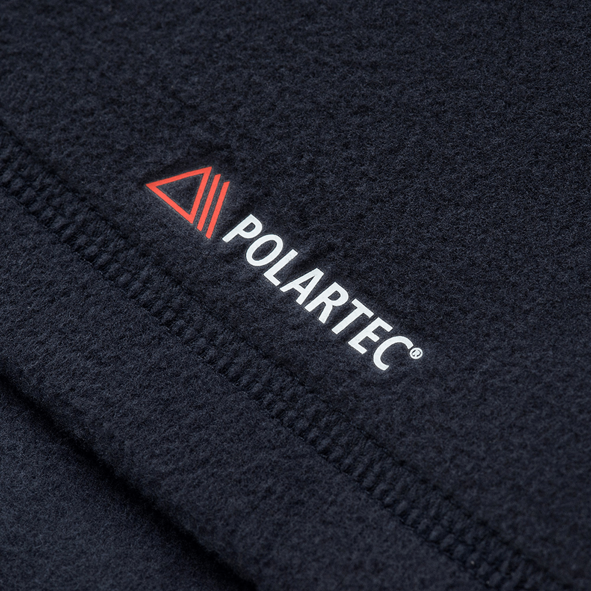 Close-up af Polartec-logoet på M-Tac Delta Polartec Fleecejakke Dame, fremstillet af 100% polyester til maksimal komfort og varme.