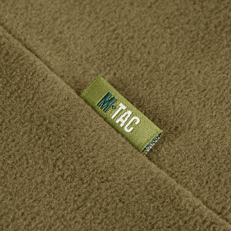 Nærbillede af M-Tac Delta Polartec Pullover Dame i olivengrøn farve med mærkelabel.