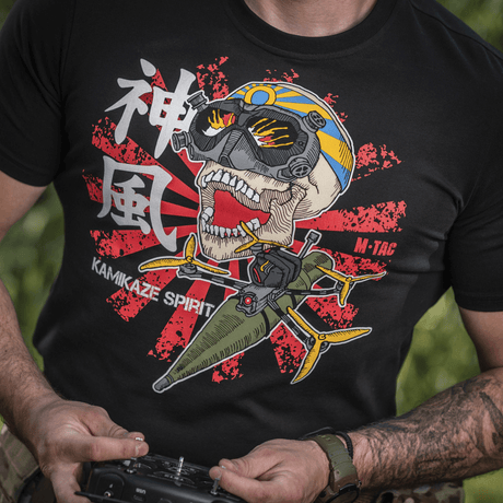 Mand iført M-Tac T-Shirt Kamikaze Spirit med stiliseret kranie og FPV-goggles på sort baggrund, japansk "Hinomaru" solflag baggrund.