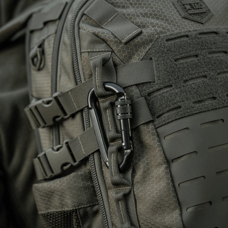 M-Tac Karabinhage 10 cm fastgjort til en rygsæk, lavet af holdbart 40Cr legeret stål, ideel til reb og slynger.