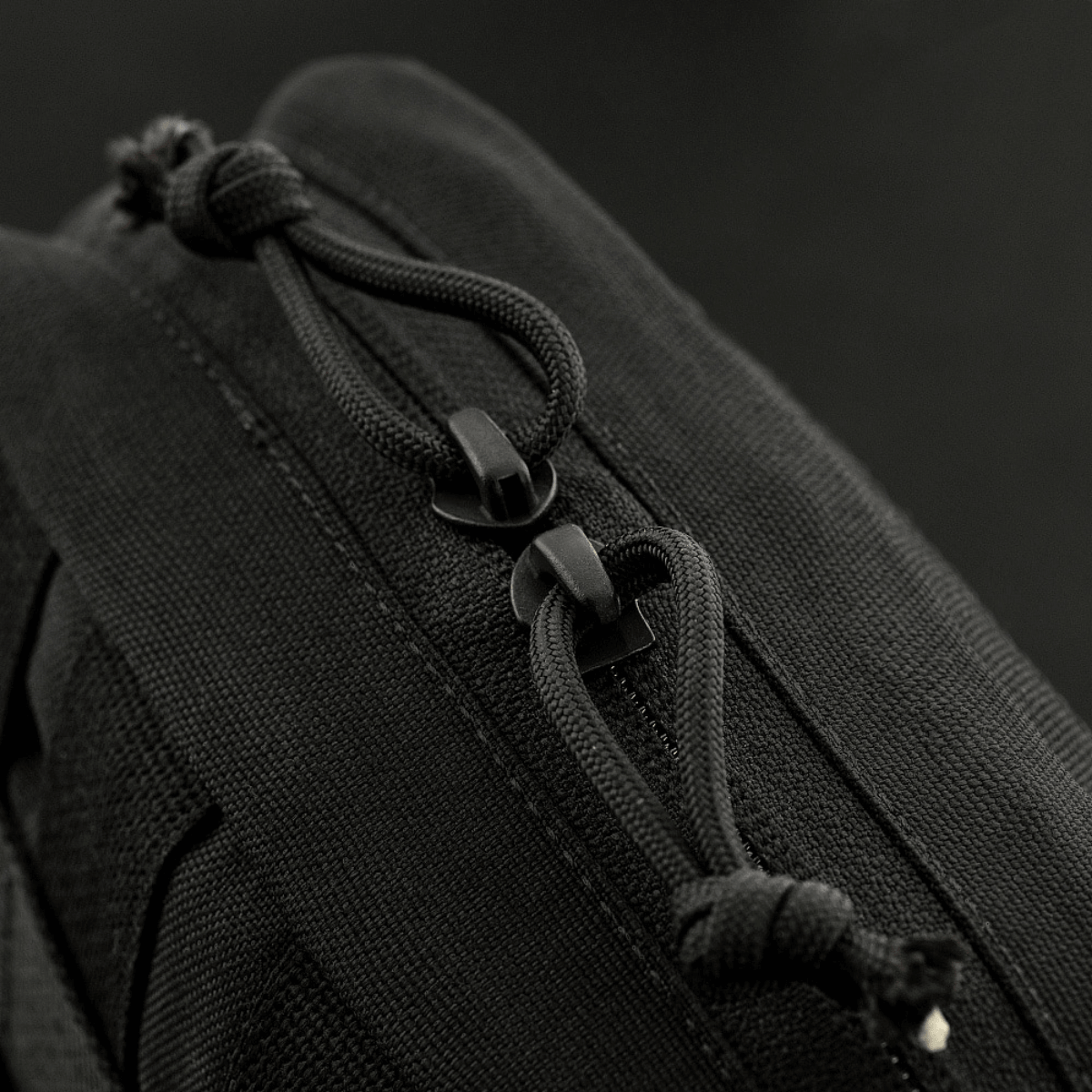 Detalje af lynlås på M-Tac organizer pouch Elite med M.O.L.L.E.-system og paracord til udendørs brug.