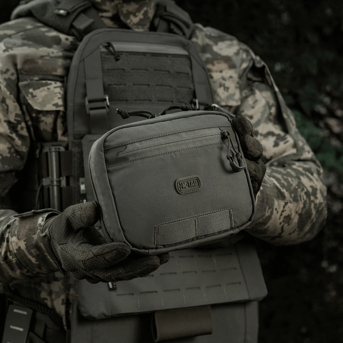 M-Tac organizer pouch Elite monteret på taktisk vest med M.O.L.L.E.-system til førstehjælp og EDC-brug. Robust design med paracord-fastgørelse.