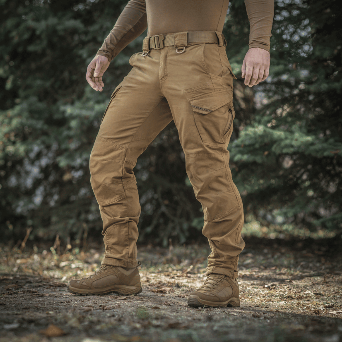 Man iklädd M-Tac byxor Aggressor Gen.II Vintage utomhus, visar robusta och stilfulla egenskaper för både fältet och vardagsbruk.