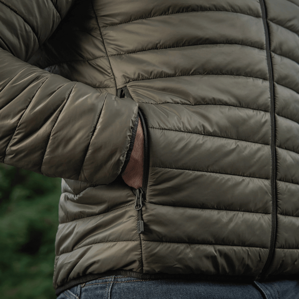 M-Tac Stalker Gen. III Primaloft Jakke med Primaloft isolering, minimalistisk design taget i brug udendørs, nærbillede af lommedetalje.