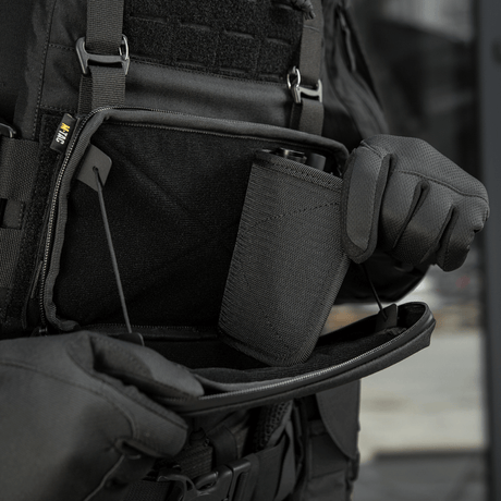 Person åbner M-Tac Admin Pouch Large Elite Gen.II med et stort rum til opbevaring af gear, fremstillet af robust Cordura 500D.