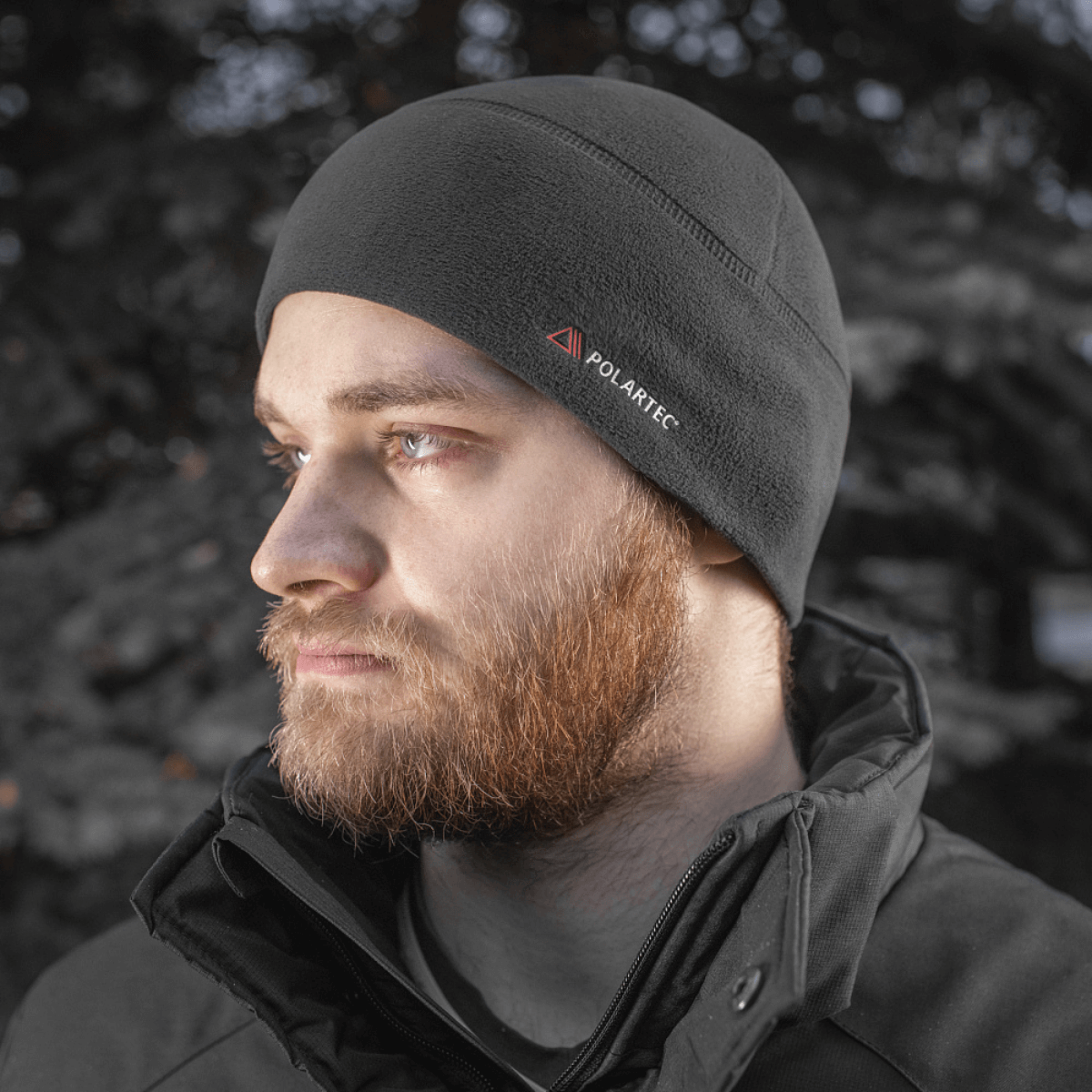 Mand iført M-Tac Fleece Watch Cap Light Polartec under en sort jakke i vintervejr