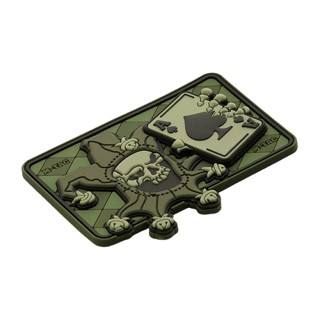 Taktisk M-Tac Patch Joker Skull 3D PVC i grønt med joker- og dødskortdesign, fremstillet af PVC med 3D-effekt, Velcro-bagside.